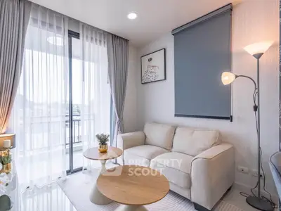 Modern living room with cozy sofa, stylish decor, and natural light from balcony window.