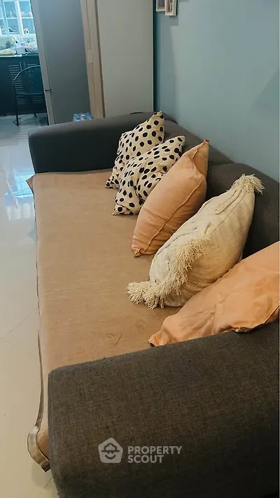 Cozy living room with stylish sofa and decorative pillows, perfect for relaxation and comfort.
