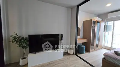 Modern living room with sleek TV setup and stylish decor in a contemporary apartment.
