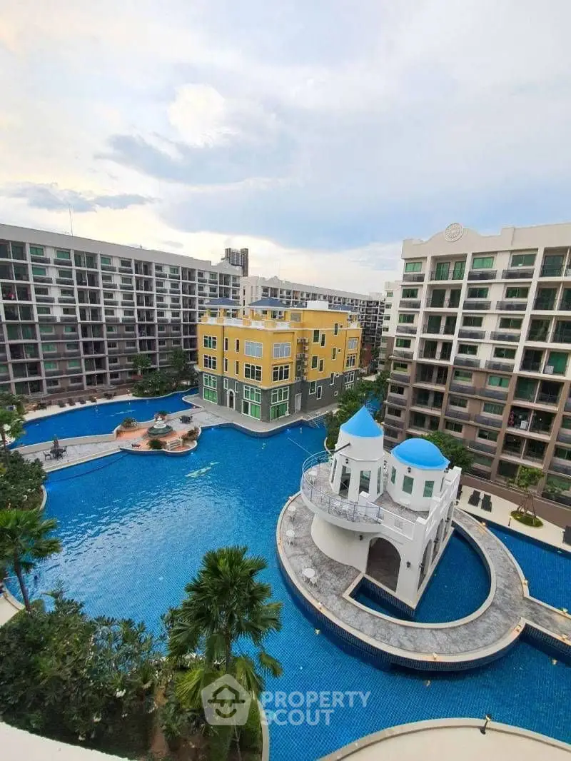 Stunning aerial view of luxury apartment complex with expansive pool and unique architectural features.