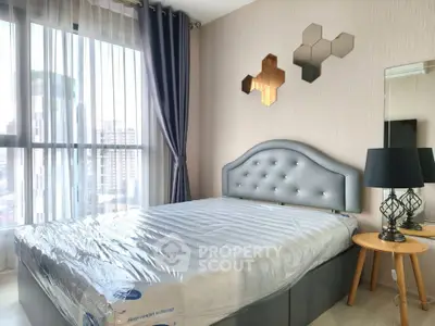 Modern bedroom with stylish decor and large window offering city views
