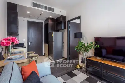 Modern living room with stylish decor and open kitchen layout, featuring a cozy seating area and contemporary furnishings.