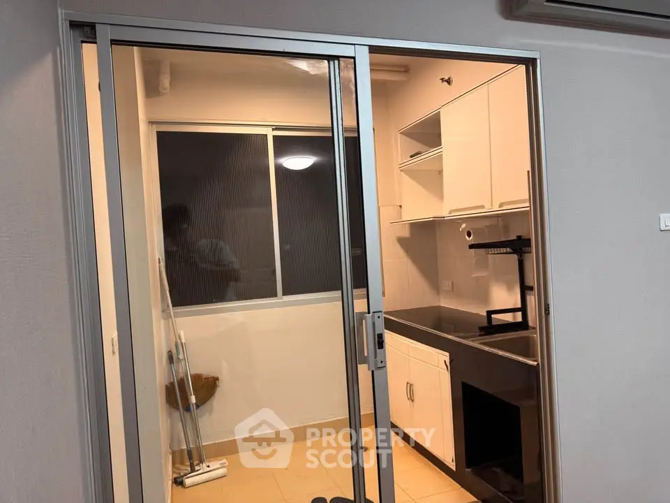 Modern kitchen with sleek cabinetry and glass sliding door