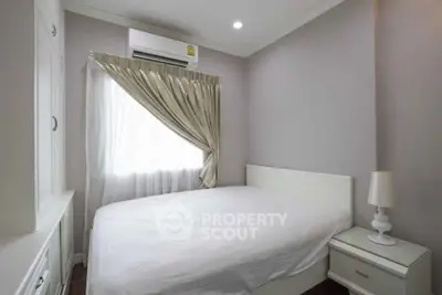 Cozy bedroom with white furnishings and natural light