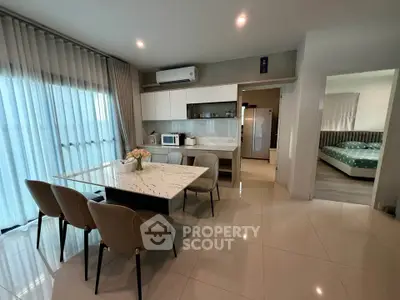 Modern open-layout kitchen and dining area with elegant marble table and stylish chairs