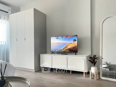 Modern living room with sleek white furniture and a flat-screen TV, perfect for cozy relaxation.