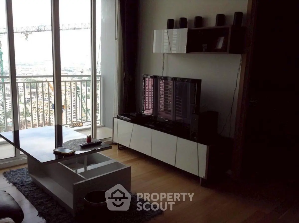 Modern living room with city view, sleek furniture, and entertainment setup.