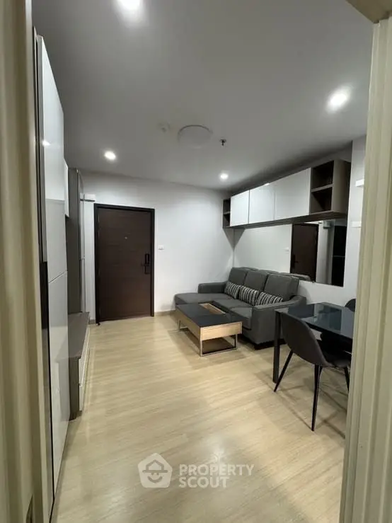 Modern living room with sleek furniture and wooden flooring in a cozy apartment.