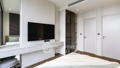 Modern bedroom with sleek design, featuring a wall-mounted TV and built-in wardrobe.