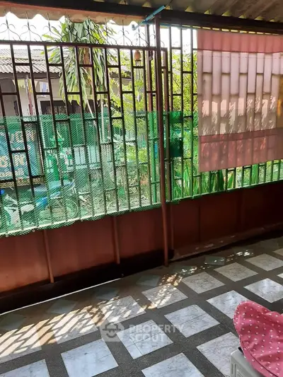 Charming balcony with garden view and decorative railing in cozy home setting.