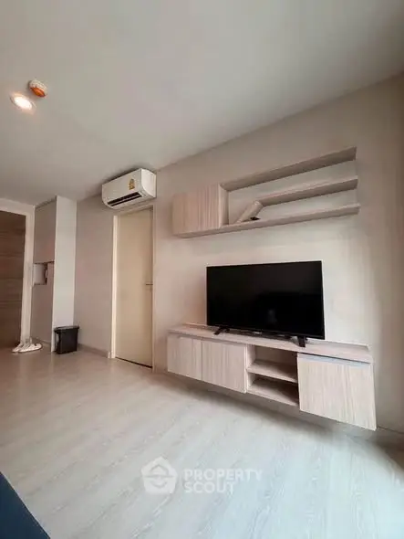 Modern living room with sleek TV unit and air conditioning in a stylish apartment.