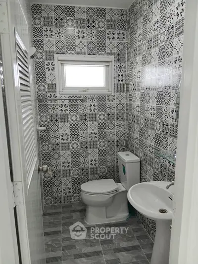 Chic modern bathroom with patterned tiles and compact design