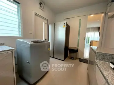 Modern kitchen with washing machine and stainless steel appliances