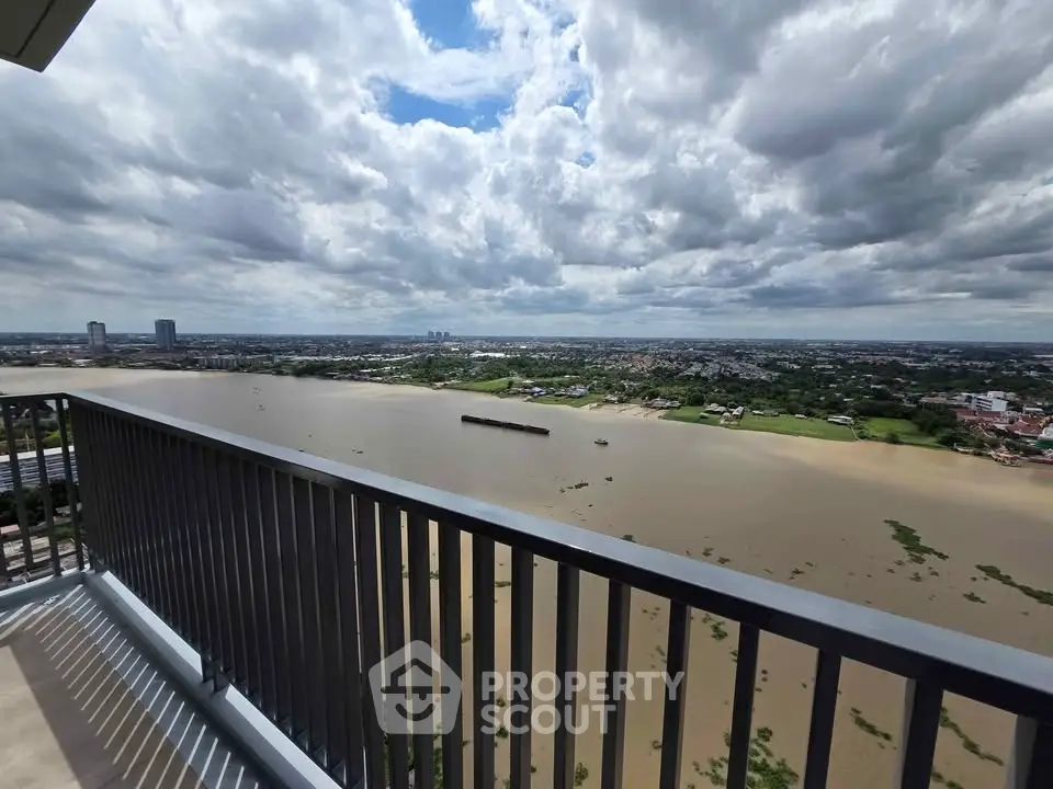 Stunning river view from high-rise balcony with expansive cityscape and lush greenery.