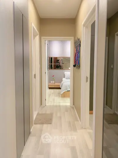 Modern hallway leading to a cozy bedroom with stylish decor and soft lighting.