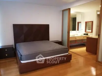 Spacious bedroom with ensuite bathroom and modern wooden flooring