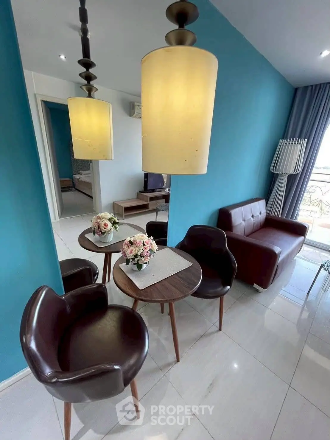 Stylish living room with modern furniture and vibrant blue walls, perfect for cozy gatherings.