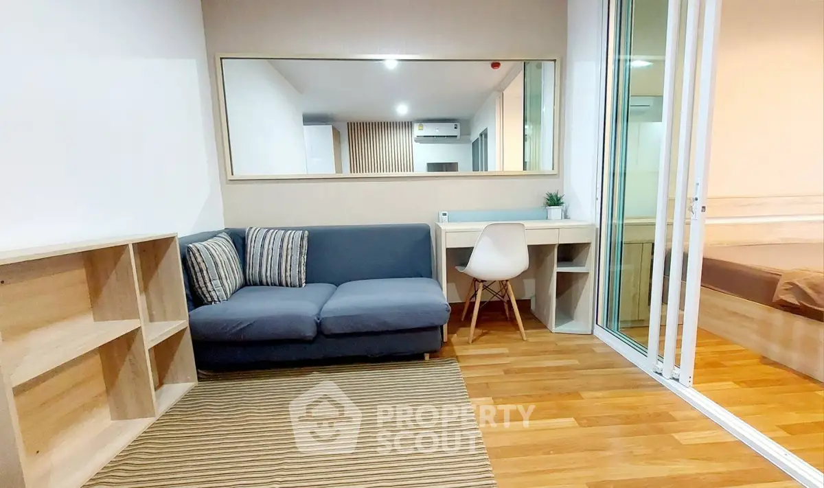 Modern living room with cozy sofa, wooden flooring, and stylish decor in a contemporary apartment.