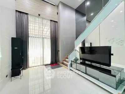 Modern living room with high ceilings and sleek staircase