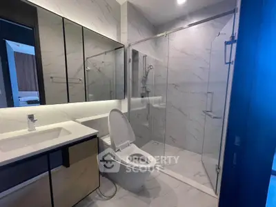 Modern bathroom with glass shower and sleek vanity in luxury apartment