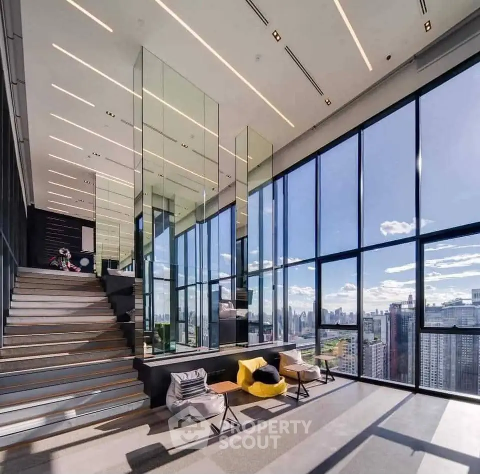 Luxurious modern living room with floor-to-ceiling windows offering stunning city views and elegant interior design.
