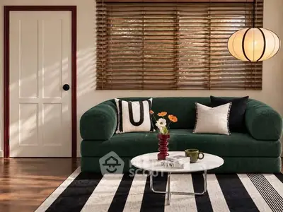 Stylish living room with green sofa, modern lighting, and chic decor