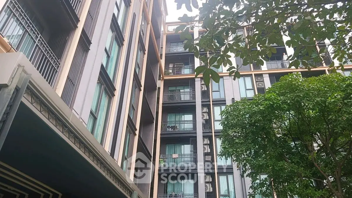 Modern apartment building with balconies and lush greenery