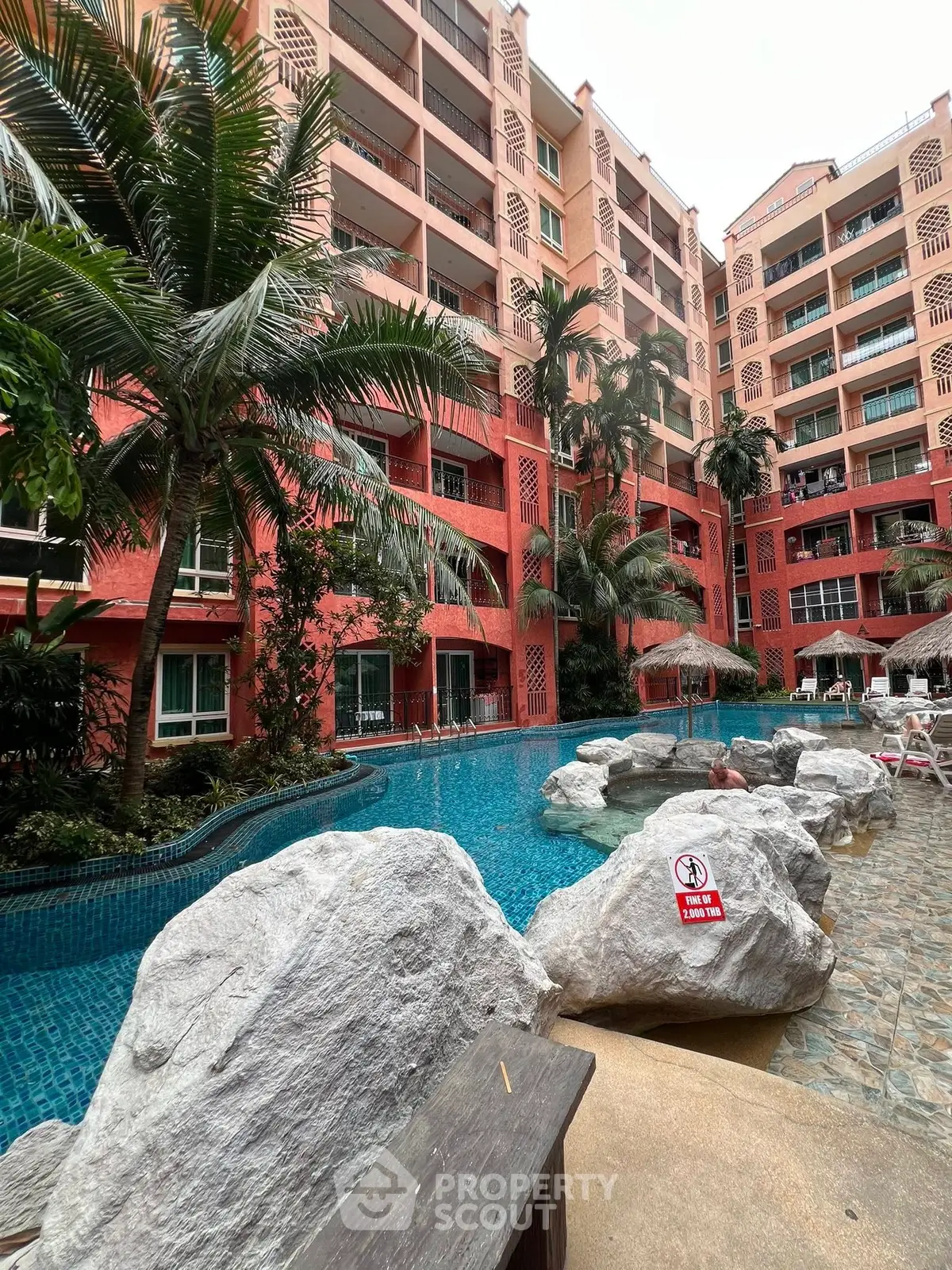 Luxurious tropical apartment complex with stunning pool and lush landscaping