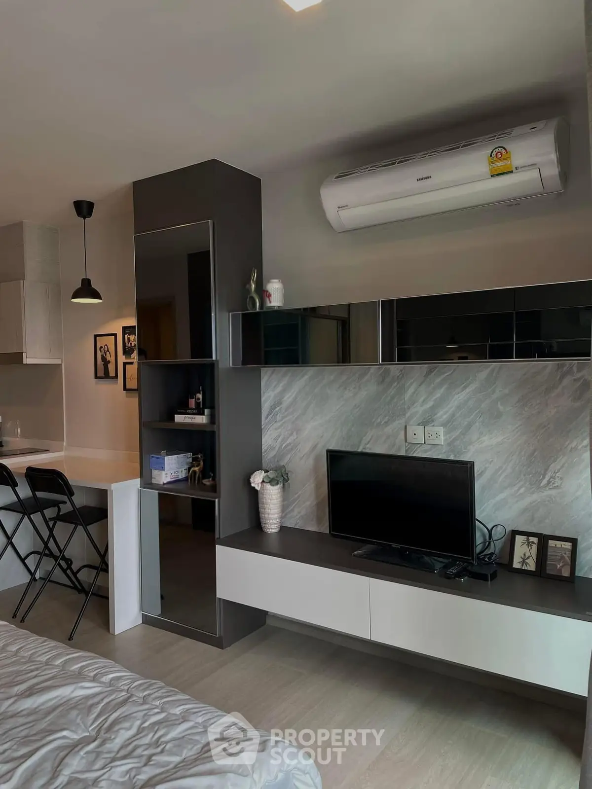Modern studio apartment with sleek interior design, featuring a compact living area and stylish furnishings.
