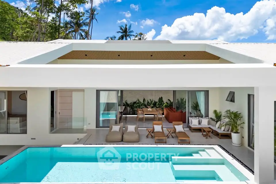 Luxurious modern villa with pool and outdoor seating in tropical setting