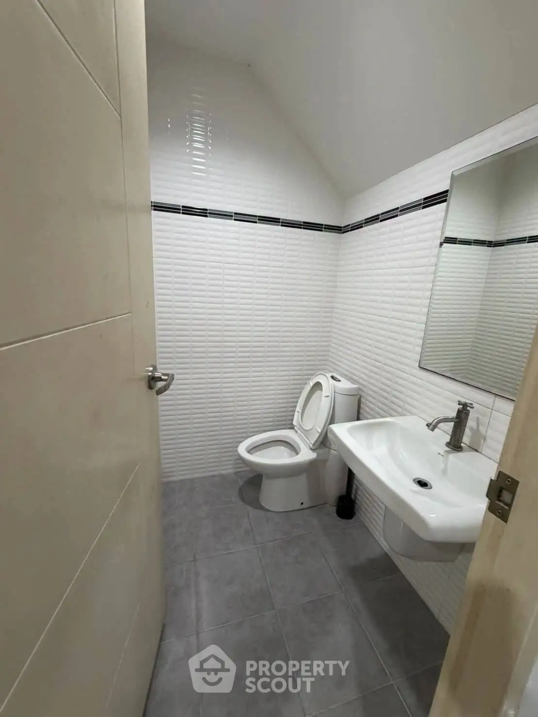 Modern bathroom with sleek white tiles and contemporary fixtures.