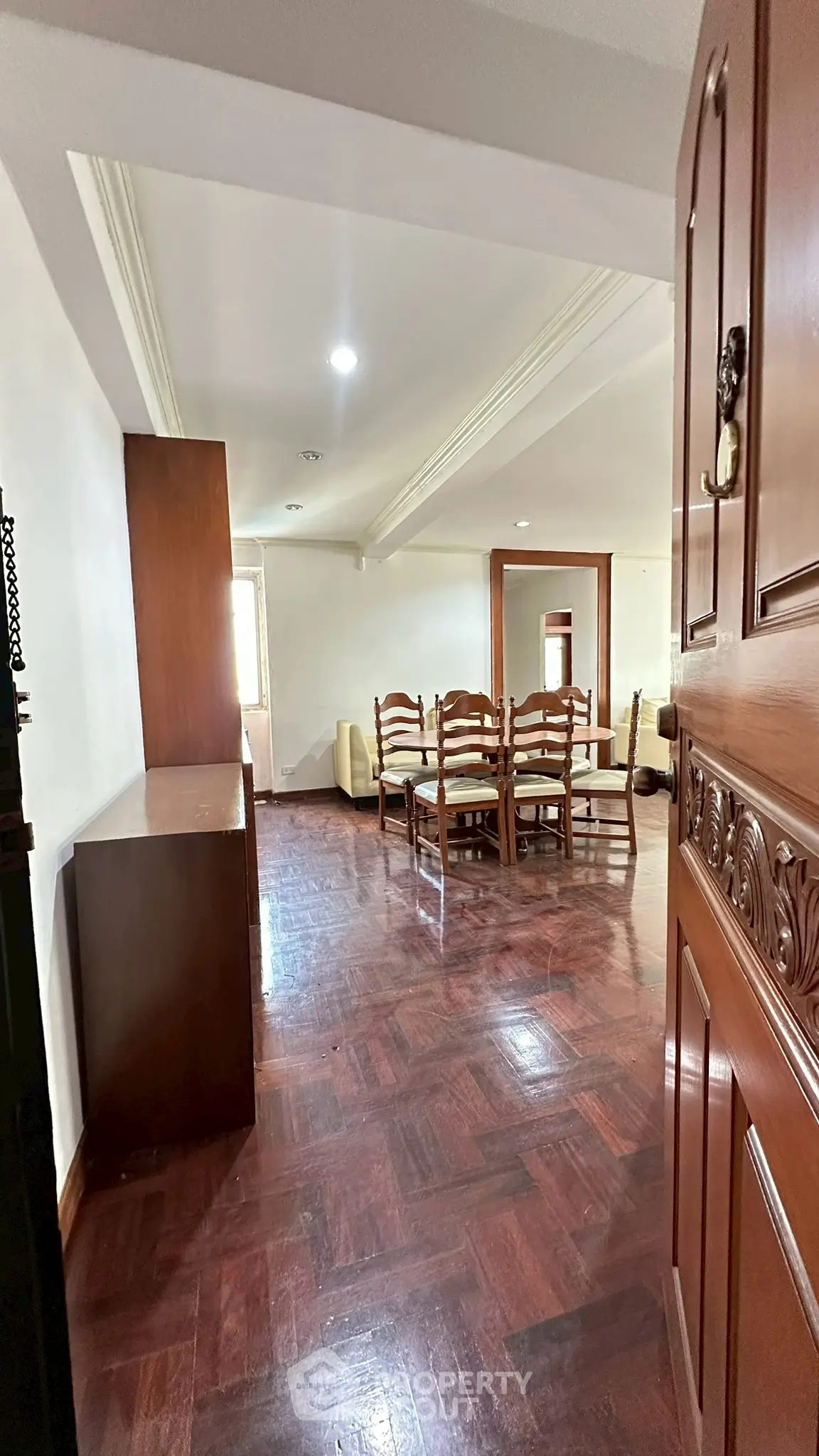 Spacious living room with wooden flooring and elegant dining set