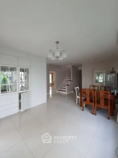 Spacious modern living area with elegant dining set and staircase