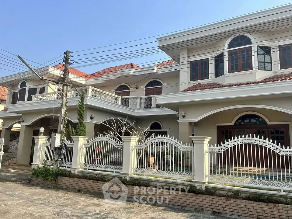 Stunning two-story house with elegant balcony and classic architecture.