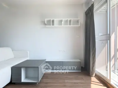 Modern living room with sleek furniture and large window for natural light.