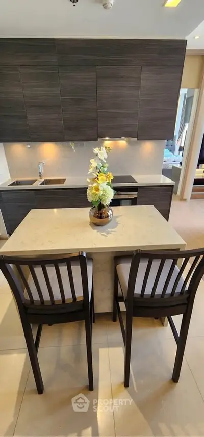 Modern kitchen with sleek cabinetry and breakfast bar in a stylish apartment.