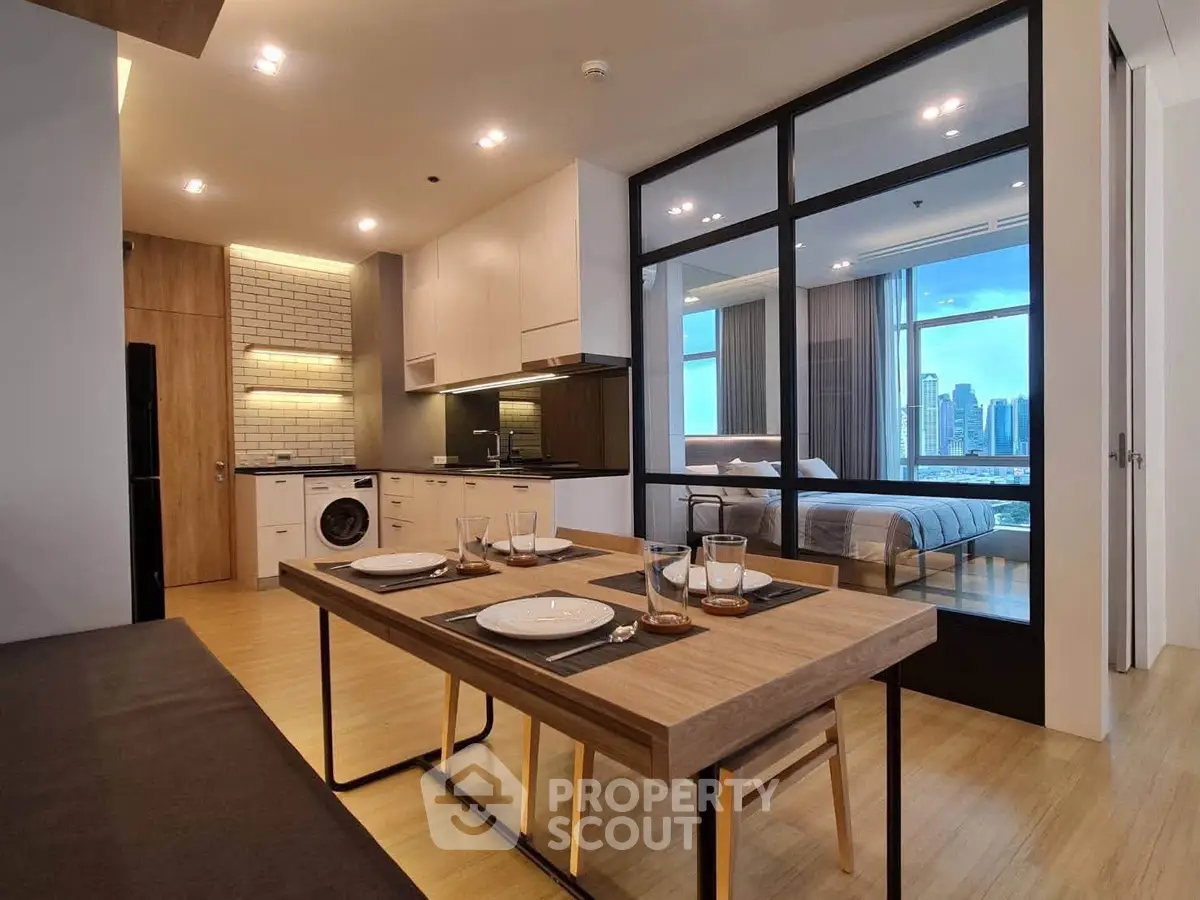 Modern open-plan kitchen and dining area with city view from bedroom
