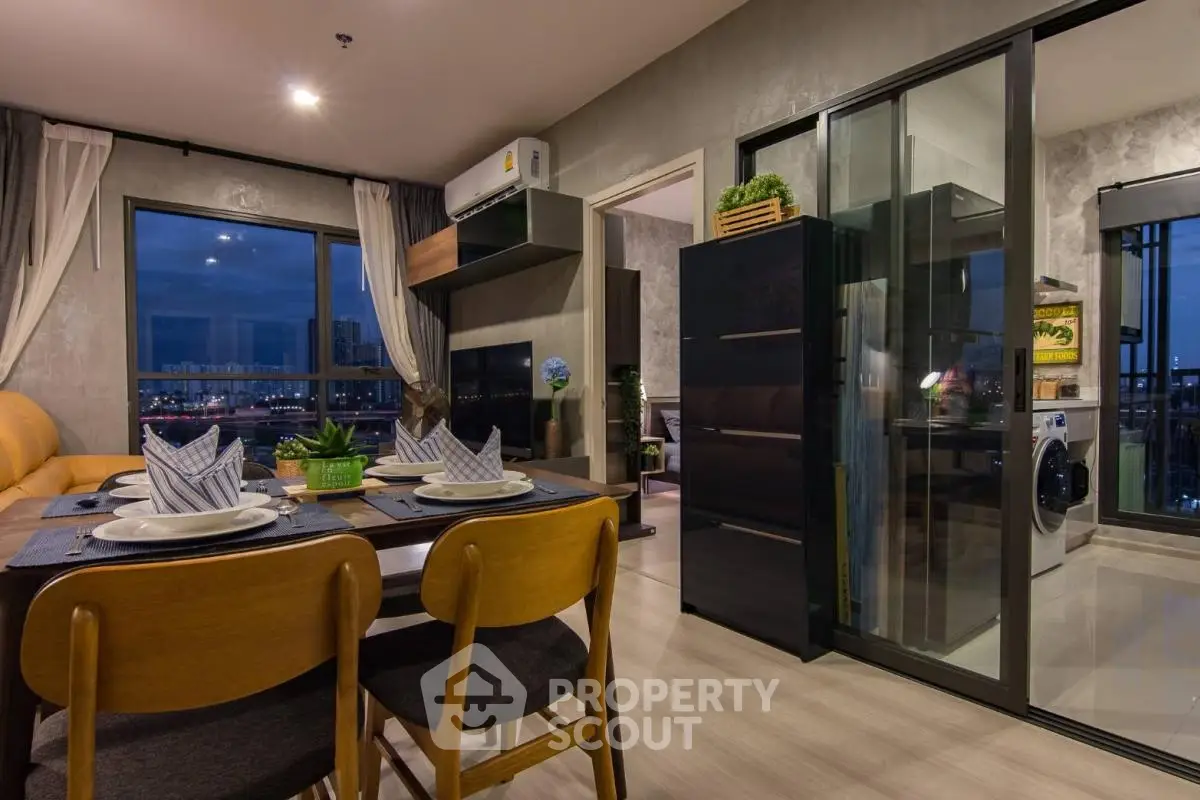 Modern open-plan living and dining area with city view and stylish decor.