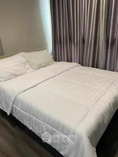Cozy bedroom with elegant curtains and comfortable bedding, perfect for relaxation.