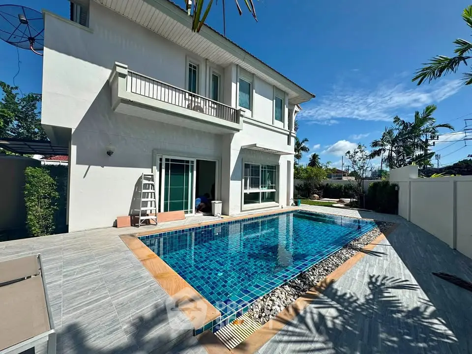 Luxurious villa with private pool and modern exterior design under clear blue sky.