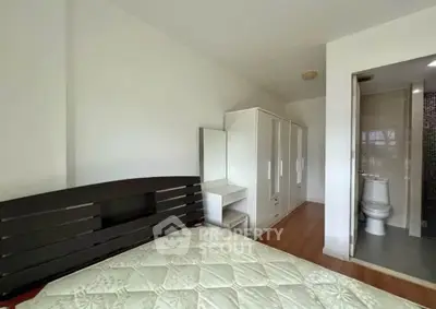 Spacious bedroom with ensuite bathroom and ample closet space in modern apartment.