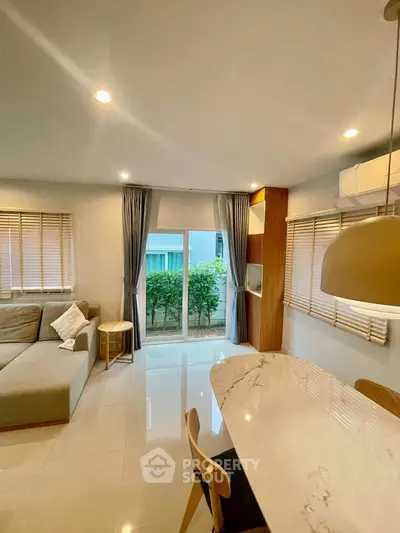 Modern living room with elegant decor and large windows for natural light.