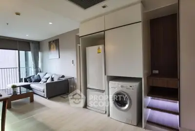 Modern living room with balcony, featuring a washing machine and fridge, perfect for urban living.