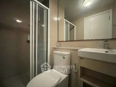 Modern bathroom with shower and sleek fixtures in a contemporary apartment.