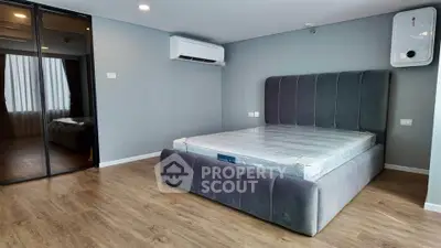 Modern bedroom with stylish bed and mirrored closet in a sleek apartment.