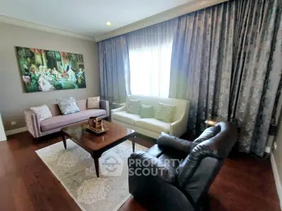 Elegant living room with classic decor, featuring plush sofas, a leather armchair, and a stylish coffee table.