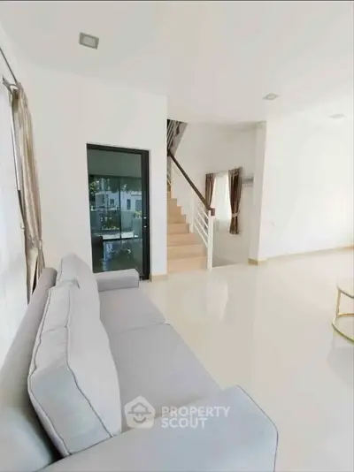 Spacious modern living room with elegant staircase and natural light