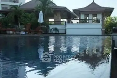 Luxurious villa with serene poolside view and tropical landscaping