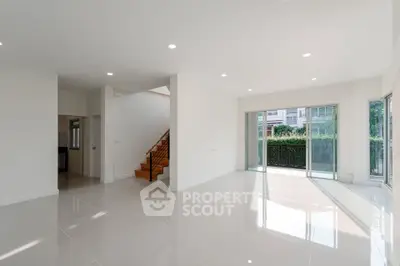 Spacious modern living room with large windows and glossy tile flooring