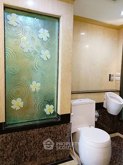 Luxurious bathroom with elegant floral glass panel and modern fixtures
